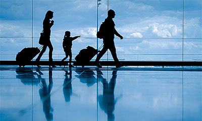 A silhouette of a family walking through an airport