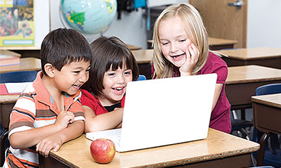 Kids having fun whilst looking at a laptop